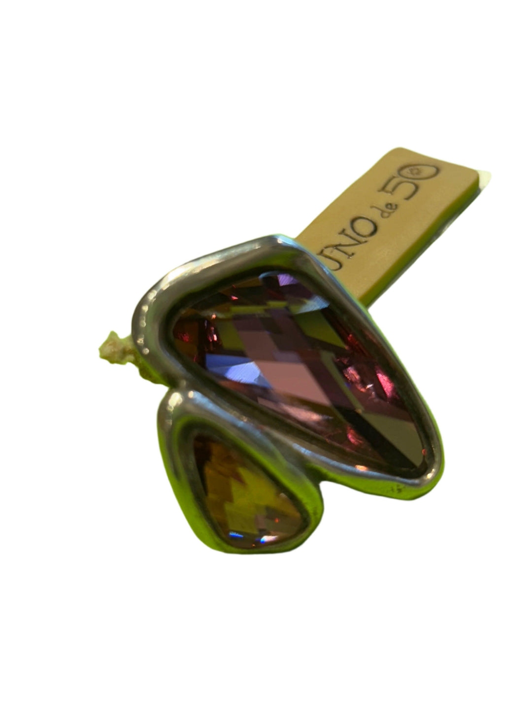 Silver ring with a multicolored gemstone on a green background